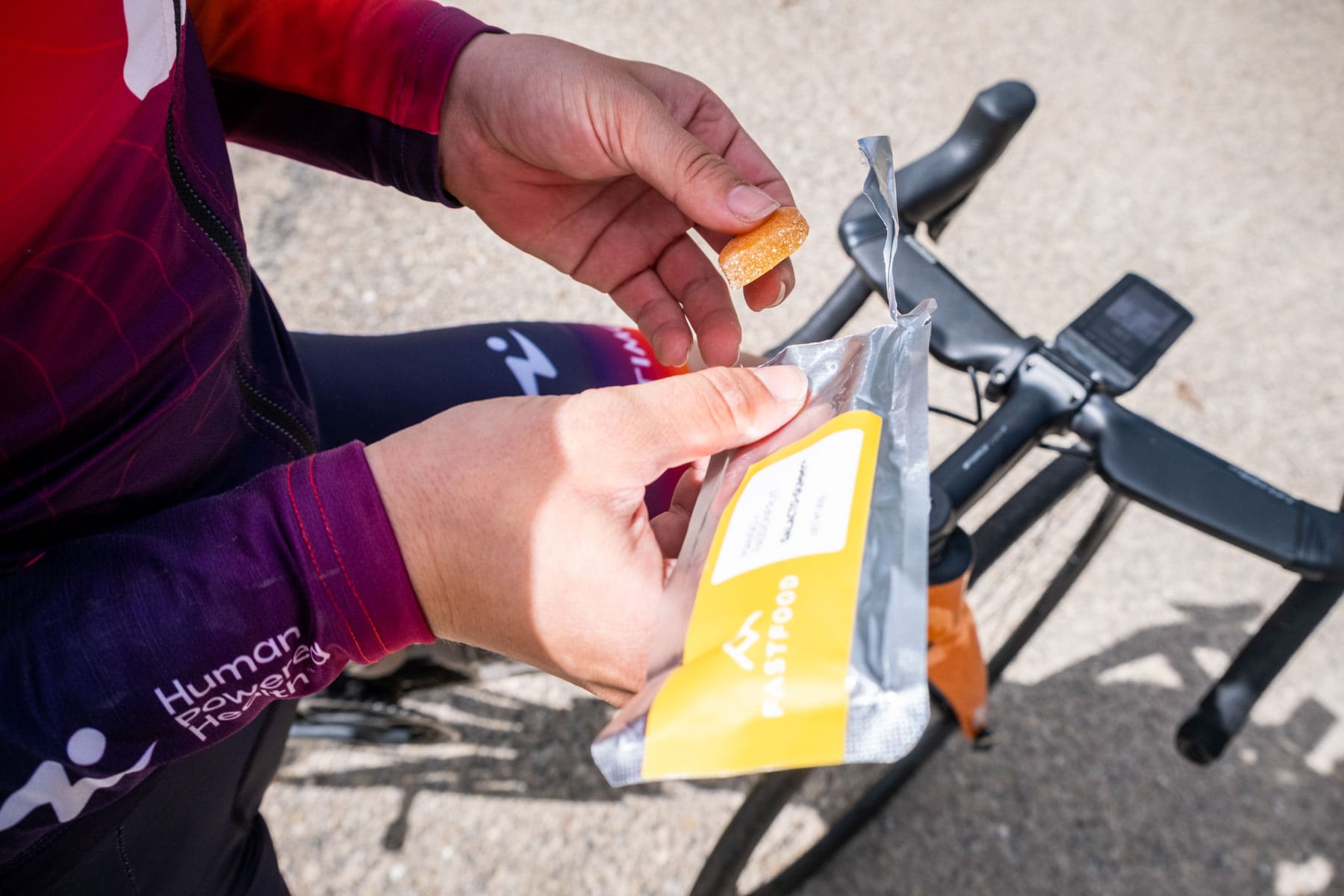 Human Powered Health cyclist getting ready for a rid eating a fastfood energy gummy