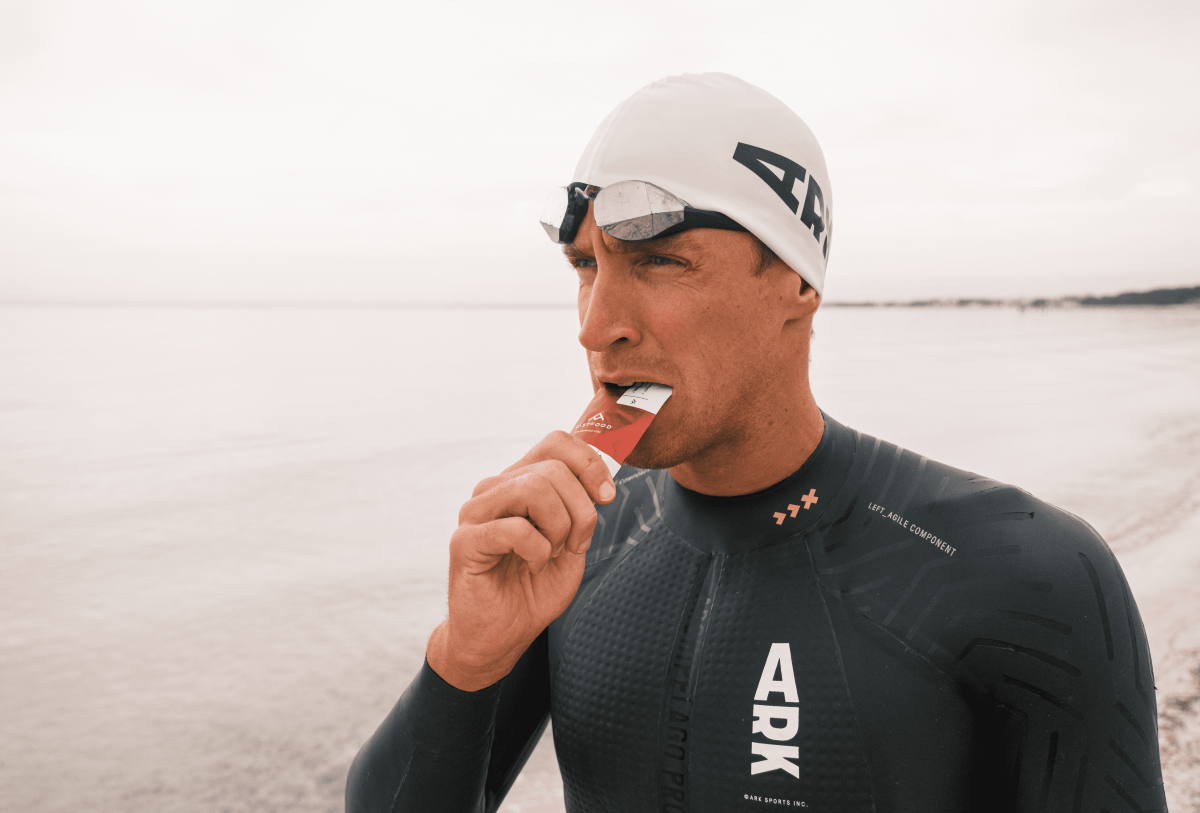 Swimmer eating a fastfood energy gel after a swim