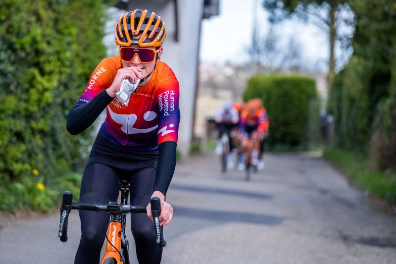 Human powered health cyclist eating fastfood energy gel during a bike ride